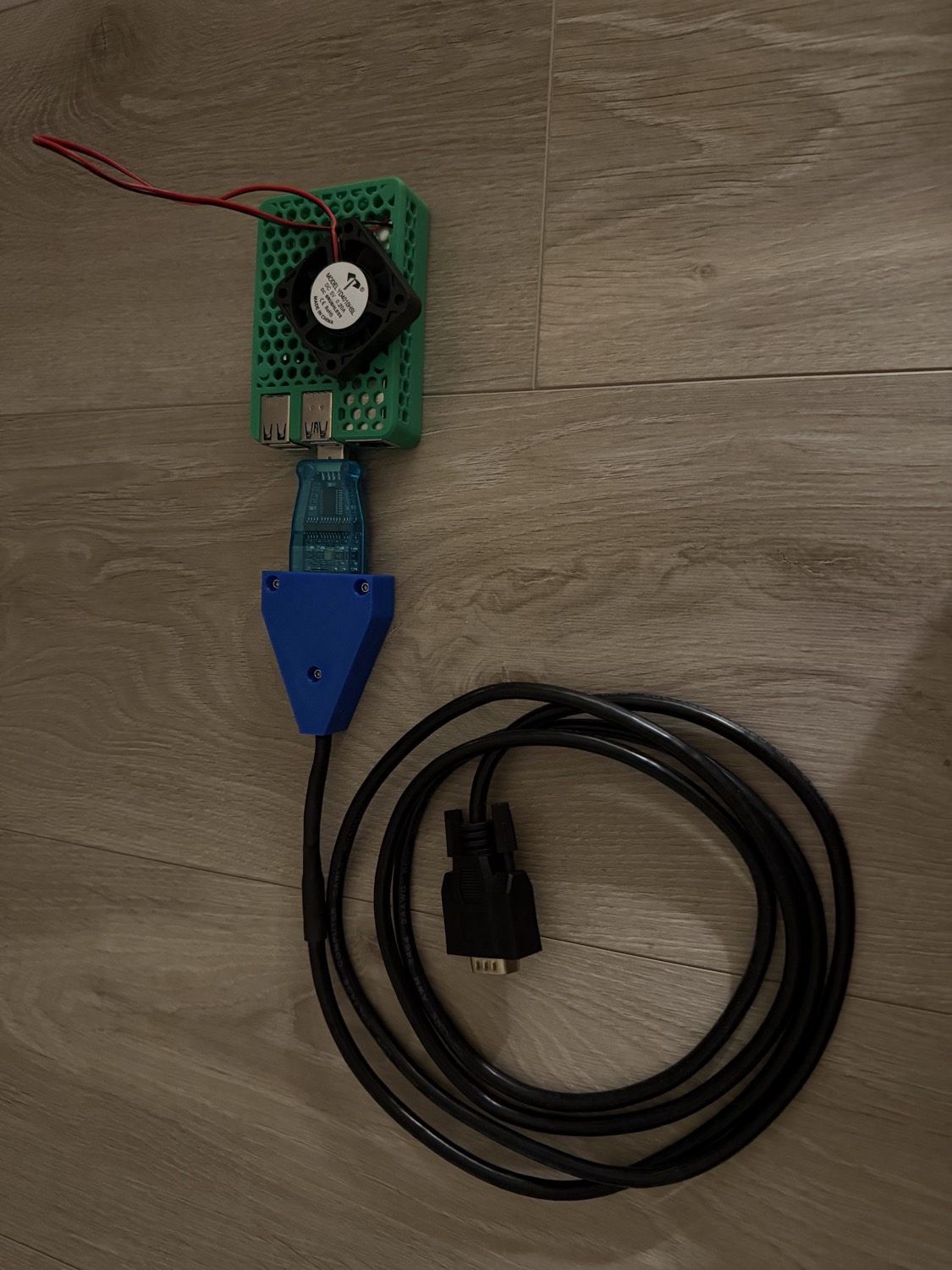 Le boîtier : Raspberry Pi (boîtier vert + ventilo) relié à un adaptateur RS-422 (boîtier bleu imprimé 3D) et au câble série DB9 du Quantum